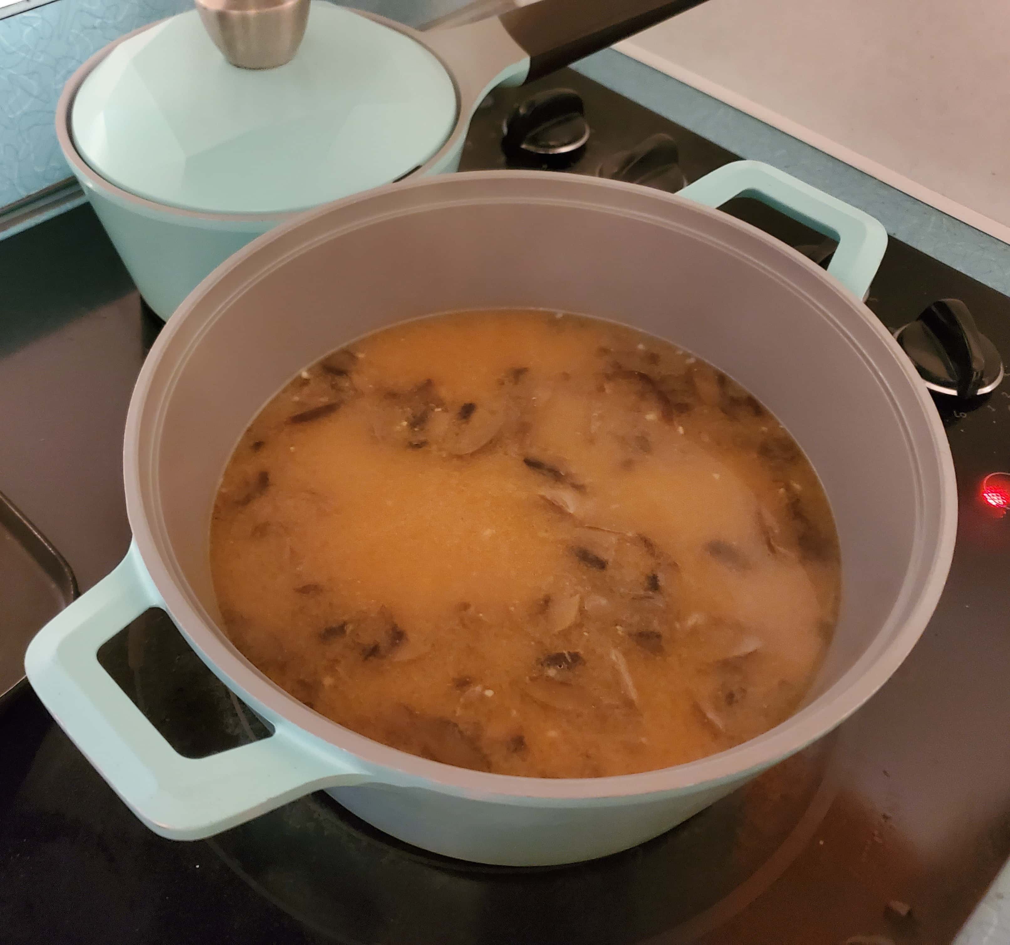 Miso and mushroom broth cooking in a pot